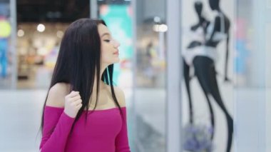 Mağaza vitrinine bakan alışverişçi kadın.