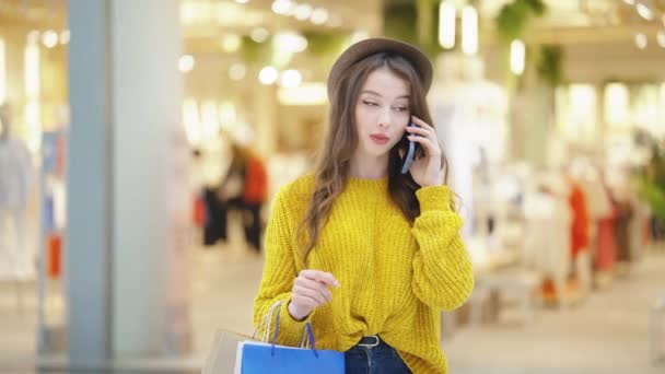 Χαρούμενη γυναίκα μιλάει στο τηλέφωνο στο εμπορικό κέντρο — Αρχείο Βίντεο