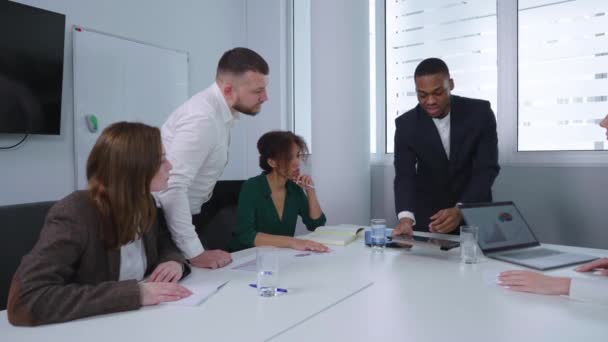 Schwarzer Geschäftsmann zeigt Team bei Treffen Grafiken — Stockvideo