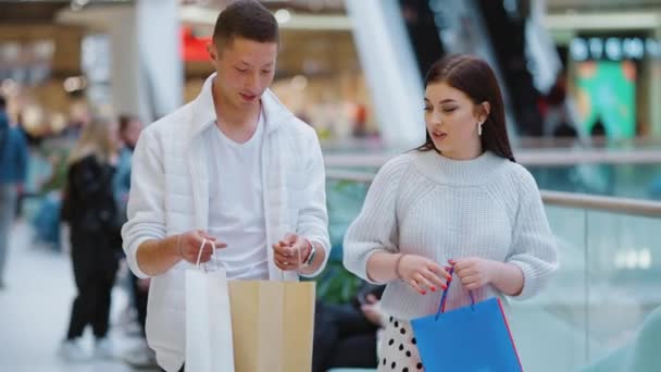 Casal andando no shopping e verificando suas compras — Vídeo de Stock