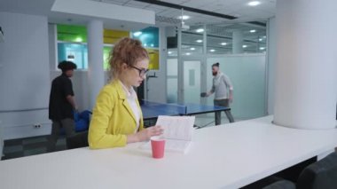 İş yerinde kahve molası sırasında kitap okuyan bir kadın.