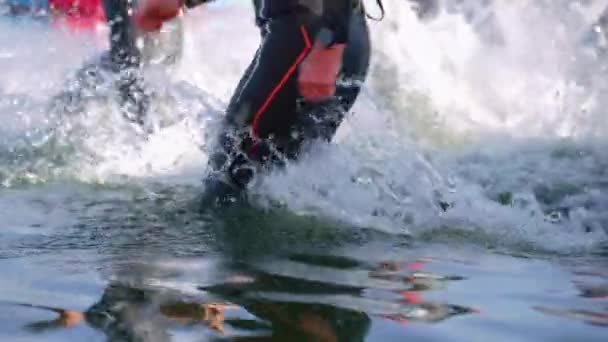 Triathleten laufen in Zeitlupe ins Wasser — Stockvideo