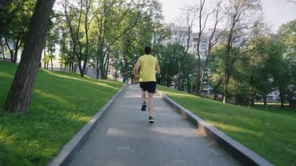 Спортсмен бегает в парке в замедленной съемке — стоковое видео