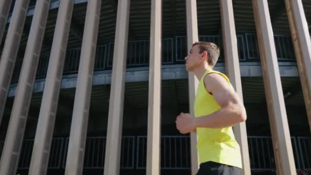 Atleta che fa jogging contro la costruzione al rallentatore — Video Stock