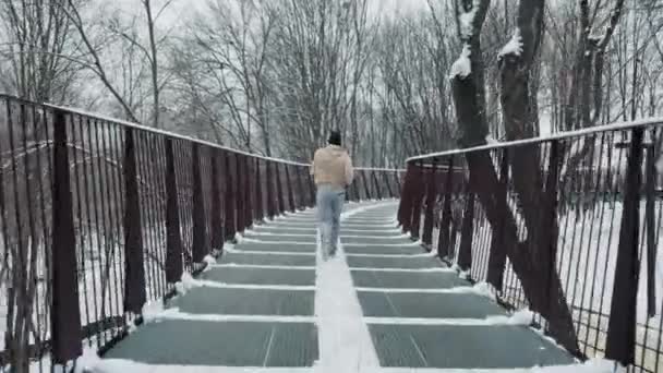 Zwolnione tempo człowiek jogging na moście w zimie — Wideo stockowe