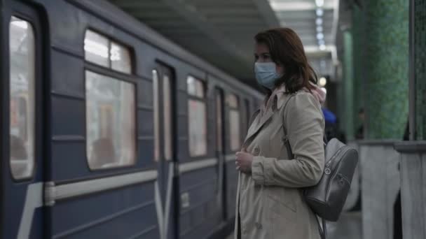 Female commuter waiting for train on subway platform — Stock Video