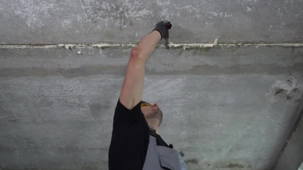 İnşaatçı tavandaki poliüretan köpüğü kaldırıyor — Stok video