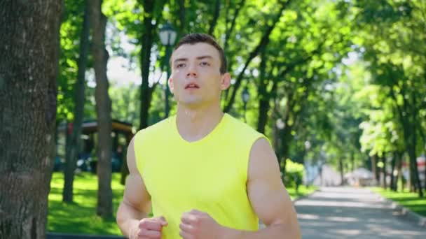 Biegacz zatrzymuje się i bierze oddech w parku — Wideo stockowe