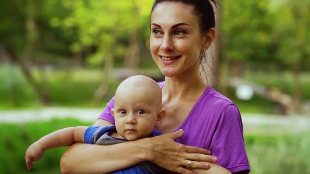 Moeder houdt baby vast en glimlacht naar de camera — Stockvideo