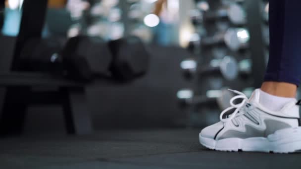 Pés de mulher colocando halteres no chão do ginásio — Vídeo de Stock