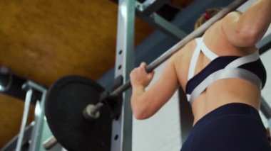 Spor salonunda halterle çalışan kadın vücut geliştirici.