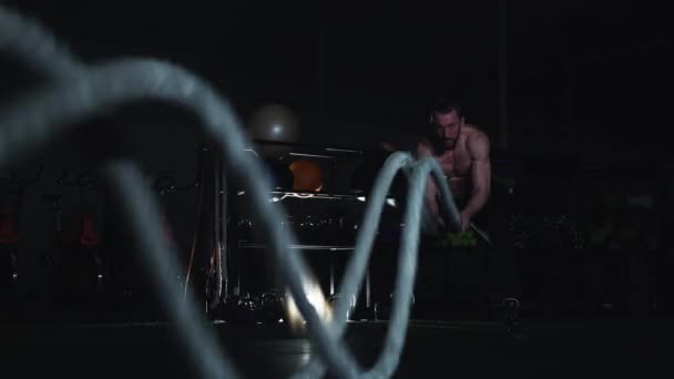 Strong man working out with battle ropes in gym — Stock Video