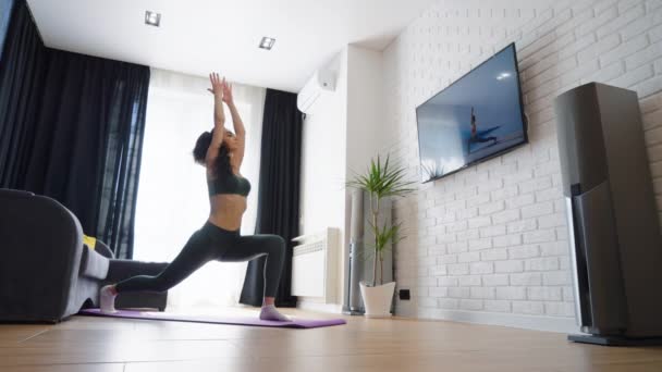 Vrouw kijken video en het doen van yoga thuis — Stockvideo