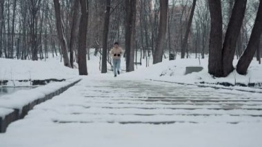 Kış parkında köprüde koşan bir adam