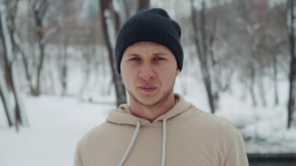 Mann posiert im Winterpark und atmet Dampf — Stockvideo