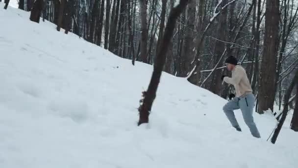 Langsom bevægelse mand kører op på snedækket bakke – Stock-video