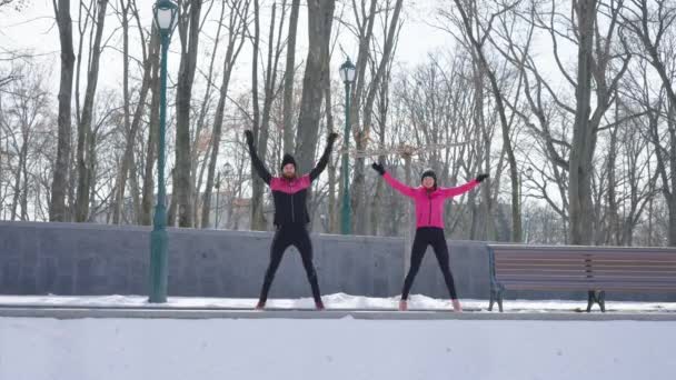 Zeitlupenmenschen springen im Winterpark — Stockvideo