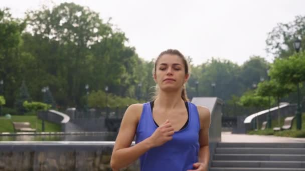 Passende kvinne som jogger i parken i sakte film – stockvideo
