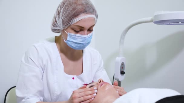 Schoonheidssalon cosmetoloog doen gezicht massage voor vrouw — Stockvideo