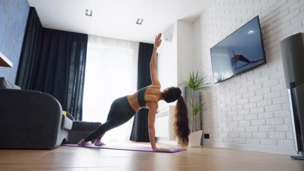 Kvinna som gör yoga medan du tittar på online tutorial — Stockvideo