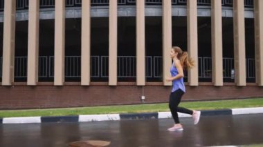 Yavaş çekim kadın otopark yakınlarında koşuyor.