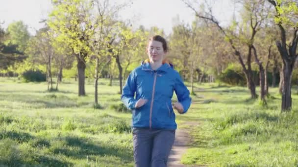 Femme au ralenti jogging parmi les arbres — Video