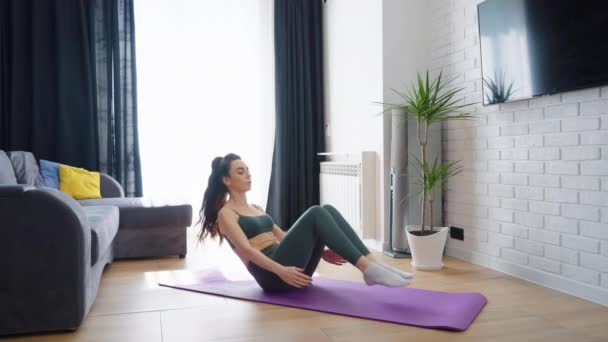 Femme s'entraînant à la maison faisant des exercices abdominaux — Video