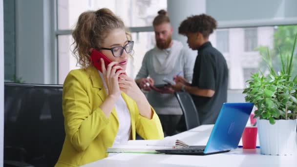 Businesswoman talking on phone and writing down information — Stock Video