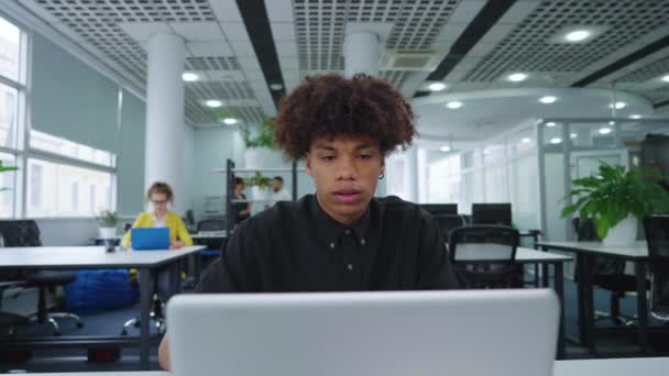 Чернокожий мужчина использует ноутбук в офисе на открытом воздухе — стоковое видео