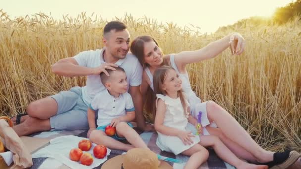 Mom taking family selfie at picnic in field — Stock Video