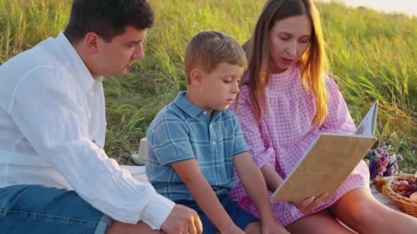 Mutter liest Jungen in der Natur Märchen vor — Stockvideo