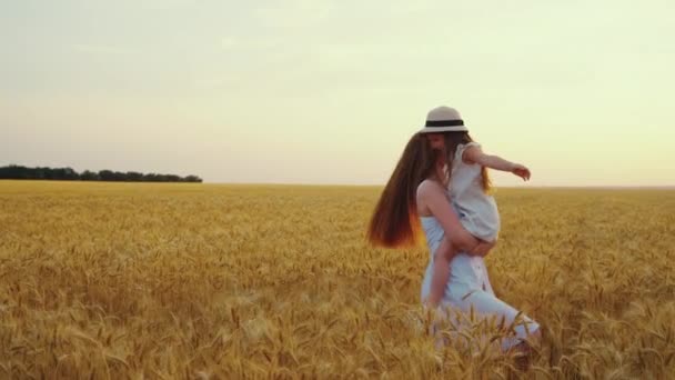 Moeder houdt dochter in de armen en draait rond in slow motion — Stockvideo