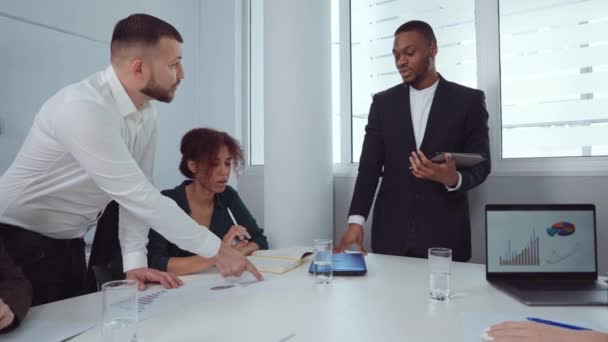 Business analisten bespreken de voortgang van het bedrijf op de vergadering — Stockvideo