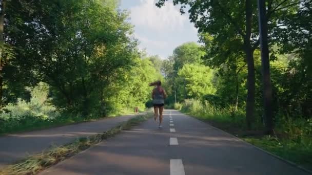 Yaz parkında ağır çekimde koşan bir kadın — Stok video