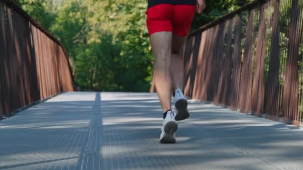 Hombre de cámara lenta corriendo en el puente por la mañana — Vídeo de stock