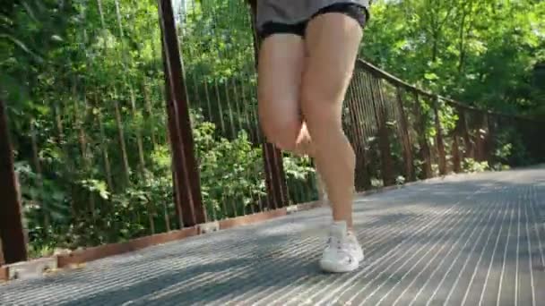Ноги женщины бегают по мосту в замедленной съемке — стоковое видео