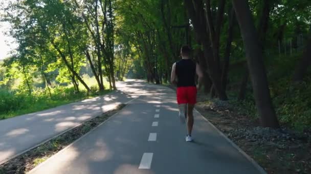 Yavaş çekim adam bisiklet yolunda koşuyor. — Stok video