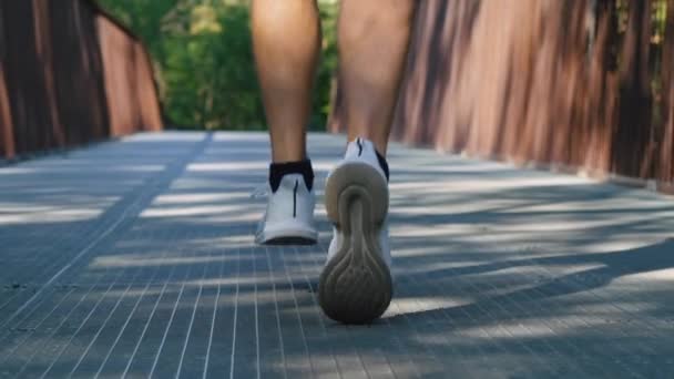 Slow motion male feet jogging on bridge in morning — Stock Video