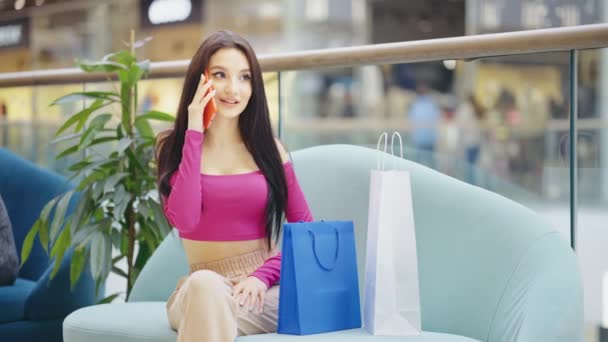 Красивая женщина разговаривает по телефону в торговом центре — стоковое видео