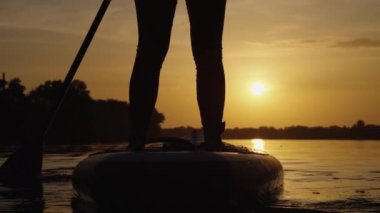 Akşamları kürek çeken bir SUP 'lu kadın.