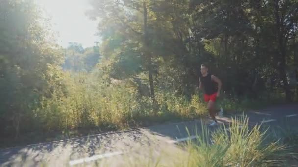 Man jogging i parken med linbanor på bakgrunden — Stockvideo