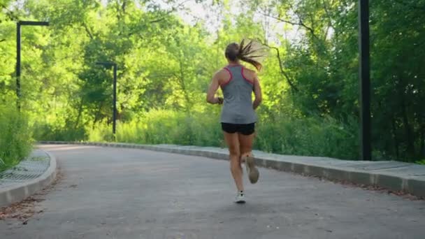 ブロンドの女性が道路上でジョギング — ストック動画