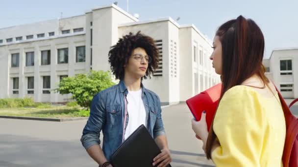 Estudiantes multiétnicos hablando cerca del edificio universitario — Vídeo de stock