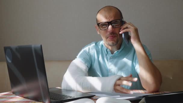 Chefe irritado com braço ferido gritando no telefone — Vídeo de Stock