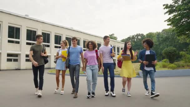 Groep van diverse studenten lopen tegen college gebouw — Stockvideo