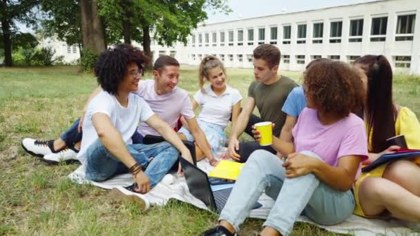 Estudantes multiétnicos relaxando no terreno no campus — Vídeo de Stock