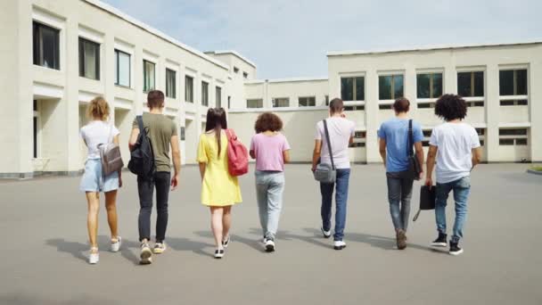 Les étudiants jetant des masques dans les airs et courant à l'université — Video