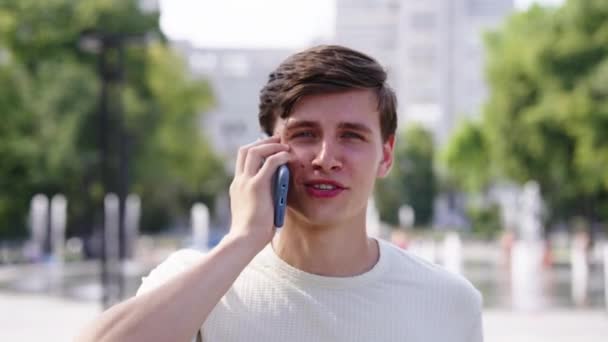 Üzletember beszél telefonon szökőkút ellen — Stock videók