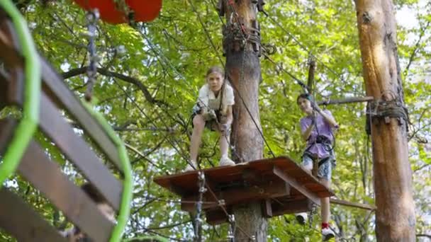 Děti se baví lezení lanová dráha v zábavním parku — Stock video