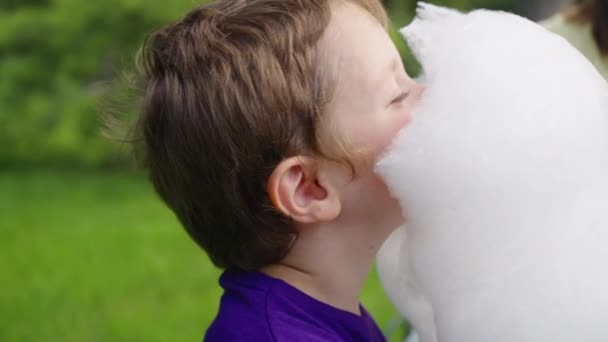 Niño comiendo algodón de azúcar en el parque — Vídeos de Stock